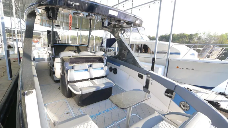 Slide: The Image of 2017 Mystic Powerboats M4200 interior with seating and table, docked at marina. - 20