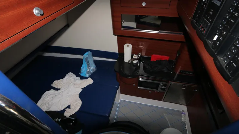 Slide: The Image of 2017 Mystic Powerboats M4200 cabin interior with wooden cabinetry and blue seating. - 23