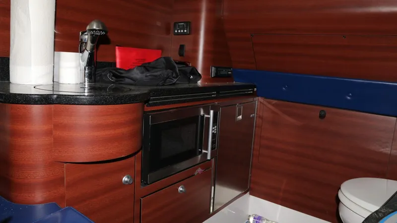 Slide: The Image of 2017 Mystic Powerboats M4200 interior with kitchenette and wood paneling. - 25