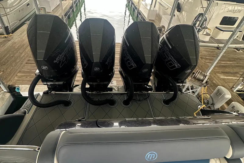 Slide: The Image of Four powerful outboard engines on a 2017 Mystic Powerboats M4200 docked at a marina. - 6