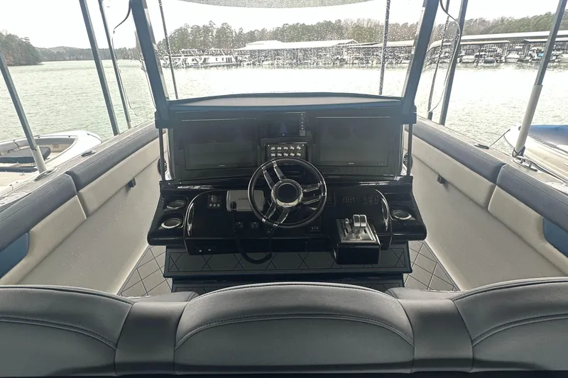 Slide: The Image of 2017 Mystic Powerboats M4200 cockpit with steering wheel and control panel, docked by the lake. - 9