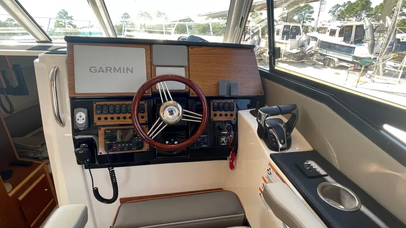 Slide: The Image of 2023 Cutwater C-288 boat helm with Garmin navigation system and wooden steering wheel. - 12