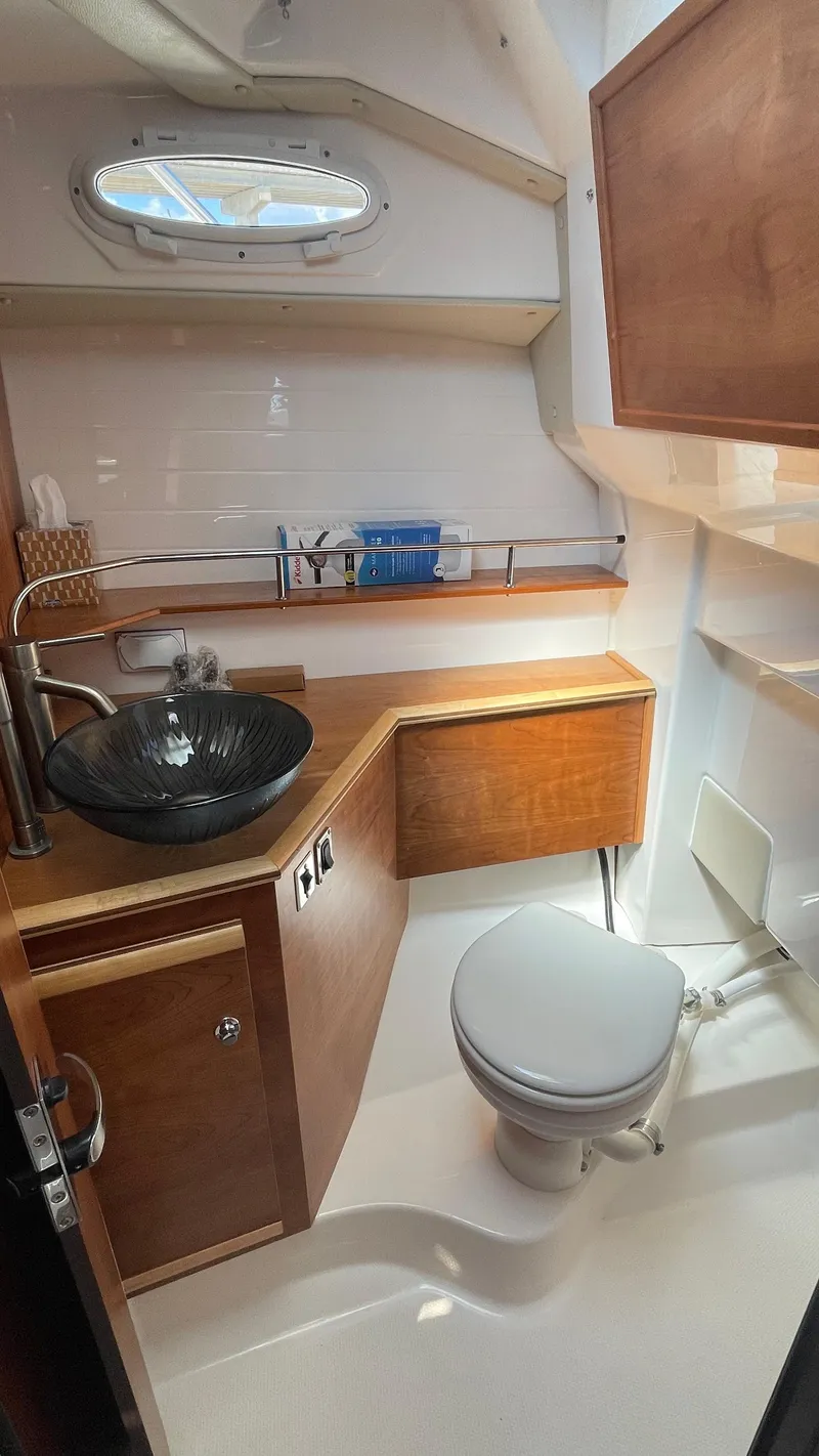 Slide: The Image of 2023 Cutwater C-288 boat bathroom with modern sink, toilet, and wooden cabinetry. - 15