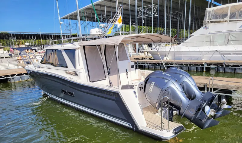 Slide: The Image of 2023 Cutwater C-288 boat docked with dual outboard engines in a marina setting. - 2