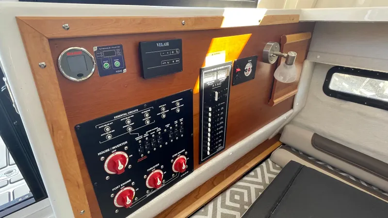 Slide: The Image of 2023 Cutwater C-288 control panel with switches and gauges in a wooden frame. - 24