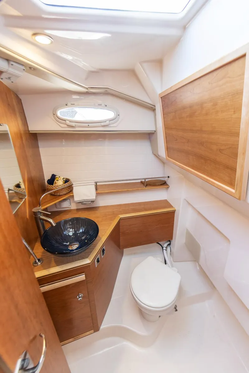 Slide: The Image of 2023 Cutwater C-288 boat bathroom with modern fixtures and wood accents. - 30