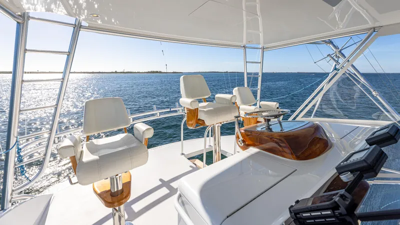 Slide: The Image of Luxurious Viking 2005 yacht helm with ocean view, featuring sleek white seating and polished wood accents. - 18