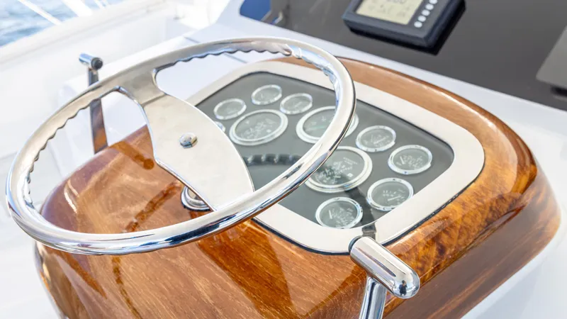 Slide: The Image of Steering wheel and dashboard of a 2004 Viking 2005 boat, featuring wood finish and gauges. - 19