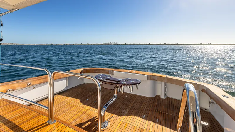 Slide: The Image of Luxury Viking 2005 yacht deck with ocean view, featuring polished wood and stainless steel railings. - 32