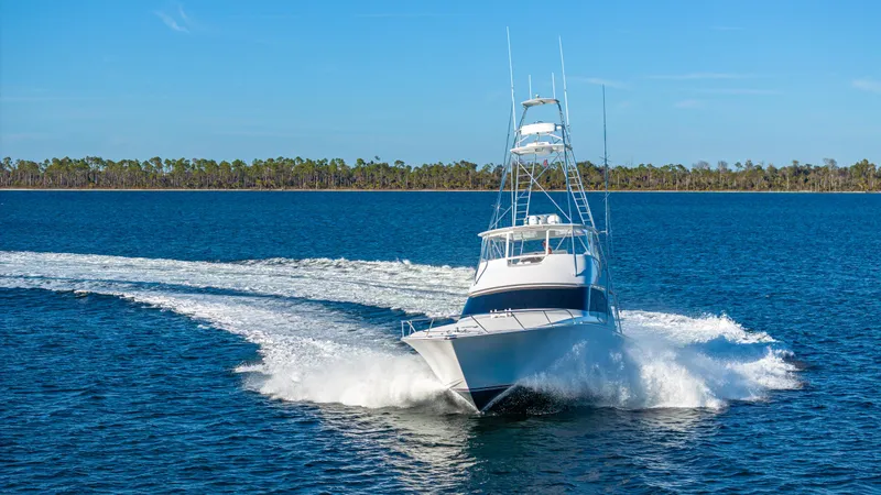 Slide: The Image of A 2004 Viking 2005 model yacht cruising on open water under a clear blue sky. - 44