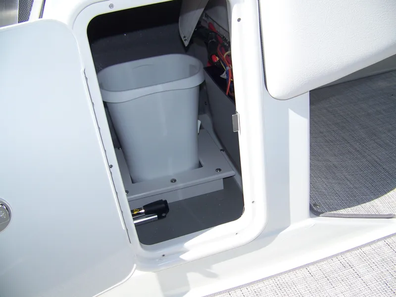 Slide: The Image of Storage compartment in 2026 Crownline Eclipse E210 XS boat, featuring a trash bin and flashlight. - 17
