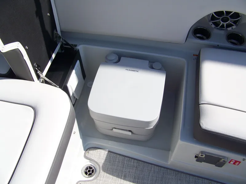 Slide: The Image of Crownline Eclipse E210 XS 2026 boat interior with portable Dometic toilet and seating. - 8