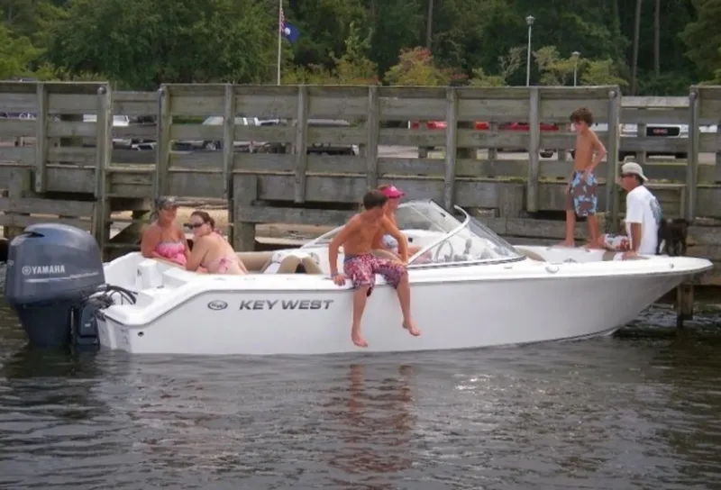 Slide: The Image of 2025 Key West 203 DFS boat with passengers docked by a wooden pier. - 1