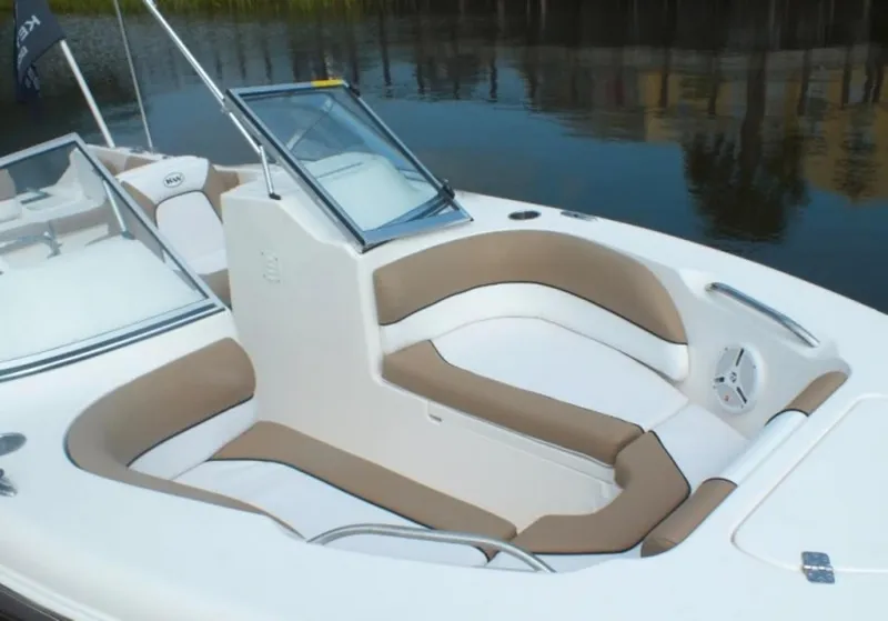 Slide: The Image of 2025 Key West 203 DFS boat interior with beige and white seating, docked on calm water. - 2