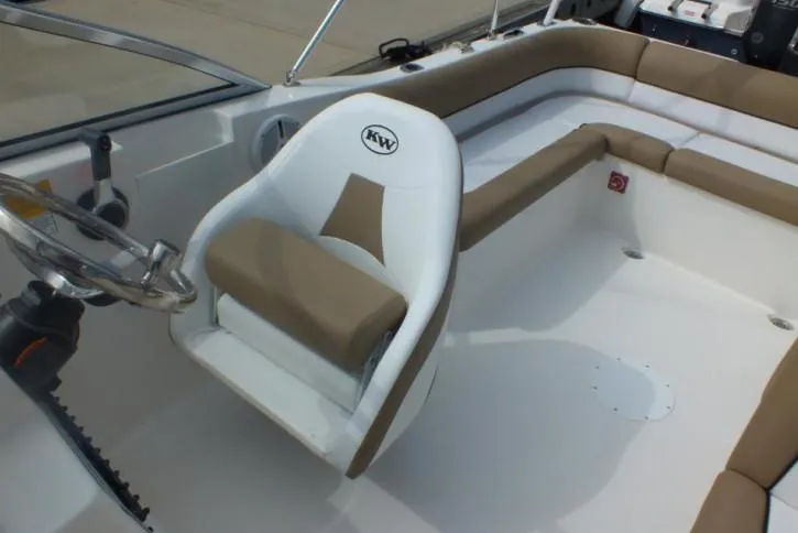 Slide: The Image of 2025 Key West 203 DFS boat interior with steering wheel and cushioned seating. - 5