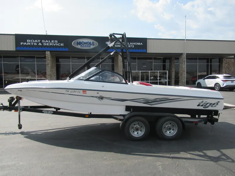 Slide: The Image of 2001 Tigé 21i/SK boat on trailer outside dealership, showcasing sleek design and branding. - 0