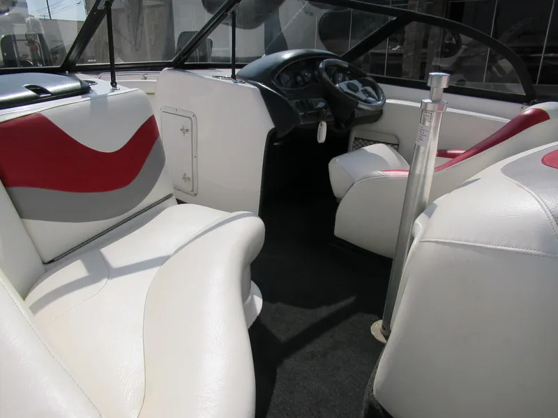 Slide: The Image of 2001 Tigé 21i/SK boat interior with white and red seating, steering wheel, and dashboard. - 7