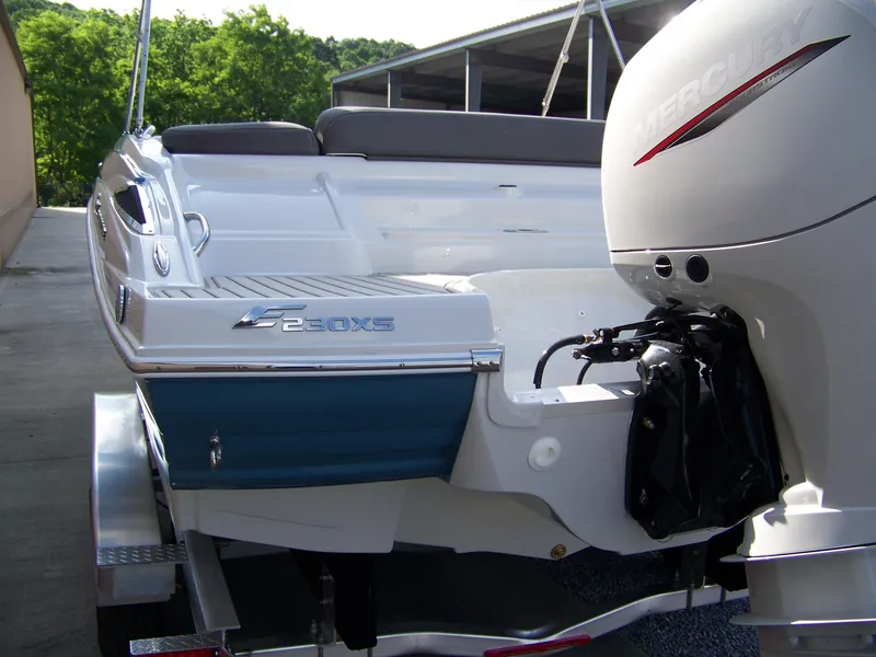 Slide: The Image of 2026 Crownline Eclipse E230 XS boat with Mercury outboard engine, docked outdoors. - 4