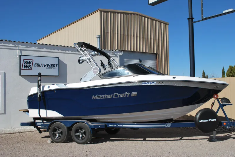 Slide: The Image of 2023 MasterCraft XT22 T boat on trailer, parked outside Southwest dealership. - 1
