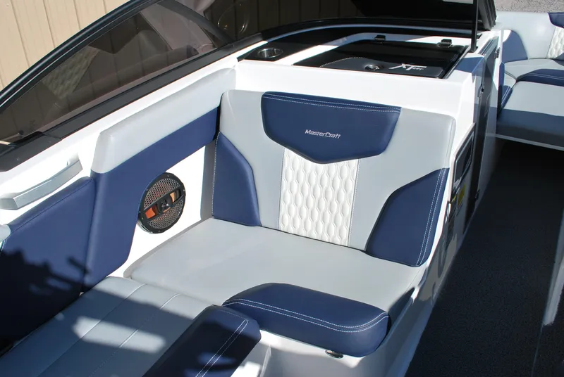 Slide: The Image of 2023 MasterCraft XT22 T boat interior with blue and white seating. - 11
