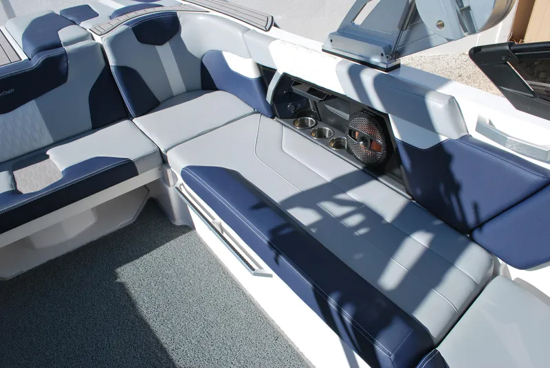 Slide: The Image of 2023 MasterCraft XT22 T boat interior with blue and gray seating and cup holders. - 12