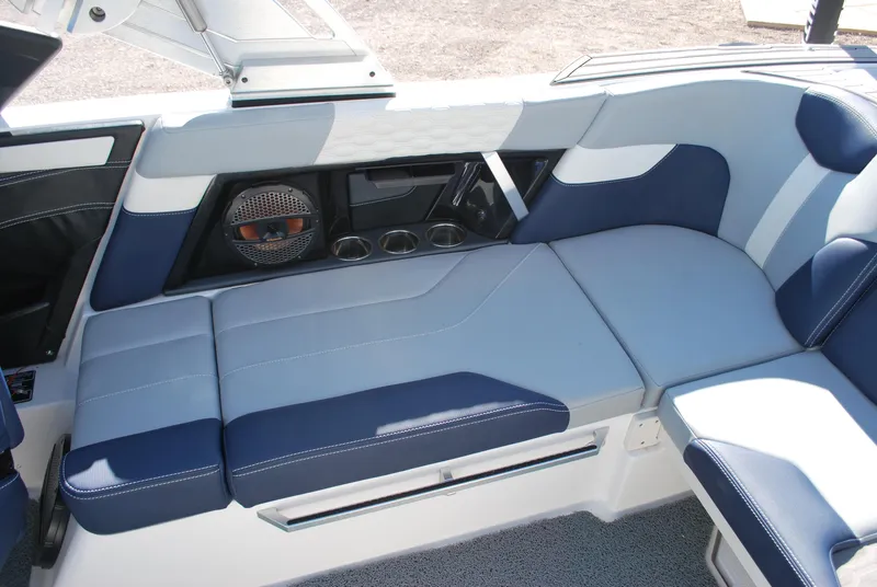 Slide: The Image of 2023 MasterCraft XT22 T boat interior with blue and white seating and speaker system. - 13