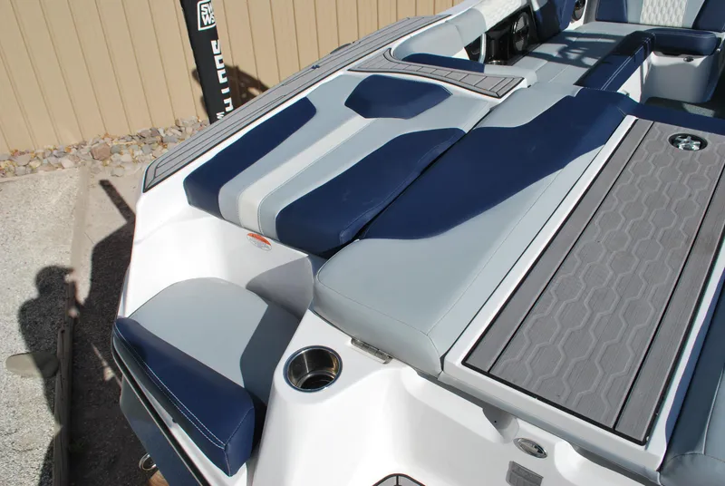 Slide: The Image of 2023 MasterCraft XT22 T boat interior with blue and gray seating and cup holders. - 16