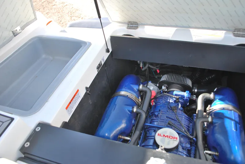 Slide: The Image of 2023 MasterCraft XT22 T boat engine compartment with Ilmor engine, featuring blue components. - 19
