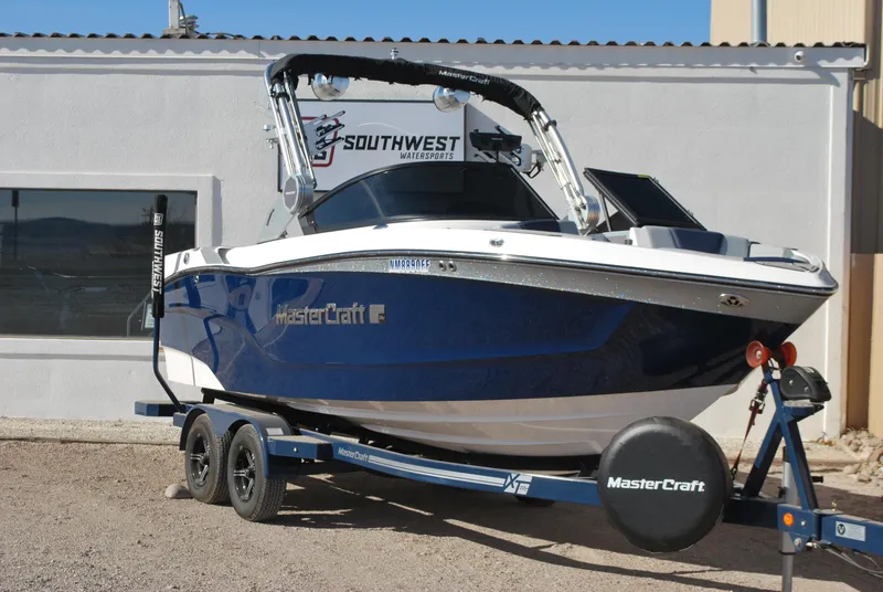 Slide: The Image of 2023 MasterCraft XT22 T boat on trailer, parked outside Southwest dealership. - 2