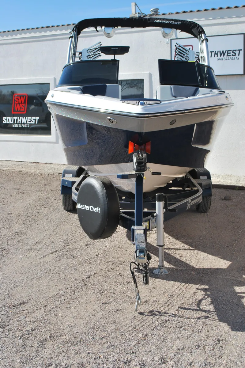 Slide: The Image of 2023 MasterCraft XT22 T boat on trailer, displayed outdoors at dealership. - 4