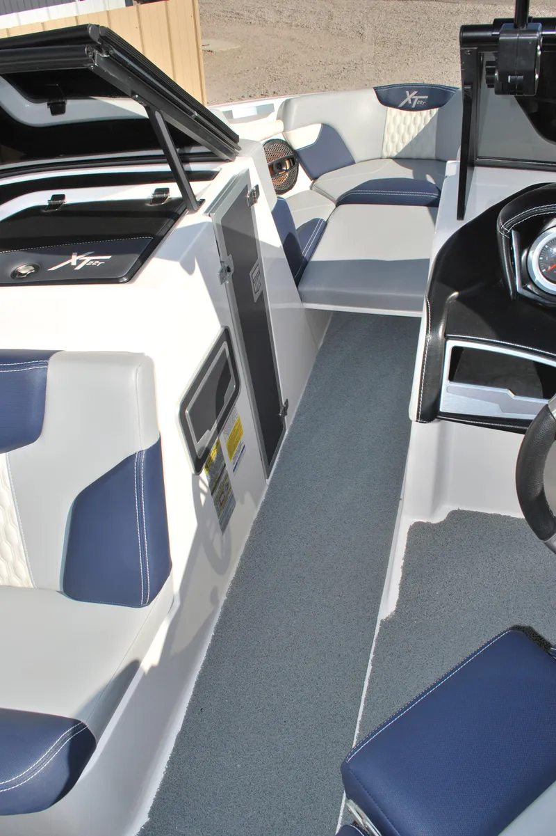 Slide: The Image of 2023 MasterCraft XT22 T interior with blue and white seating and modern dashboard. - 8