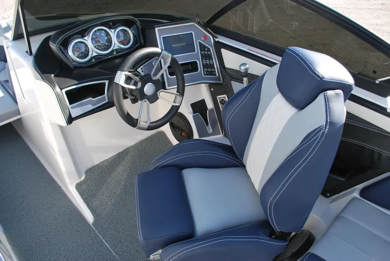 Slide: The Image of 2023 MasterCraft XT22 T boat interior with modern dashboard and blue seating. - 9