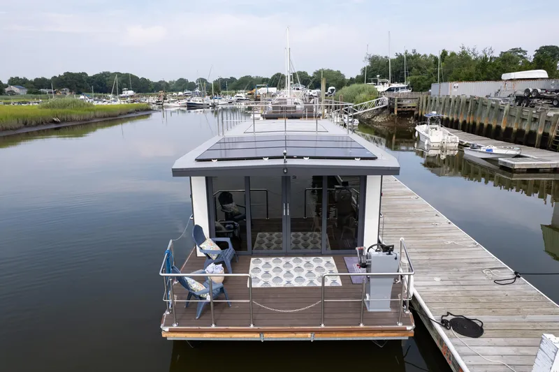 Slide: The Image of Modern Waterlodge Apart EL 2025 houseboat docked in serene marina setting. - 1