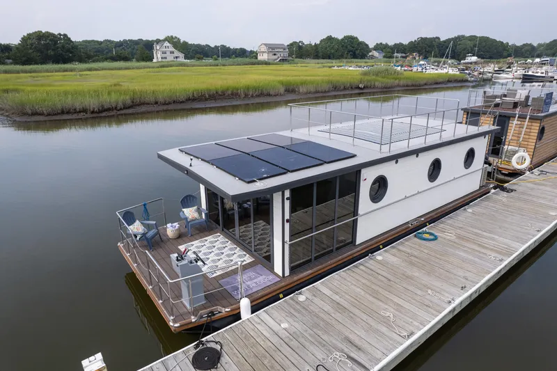 Slide: The Image of Modern 2025 Waterlodge Apart EL houseboat with solar panels docked on a serene river. - 11