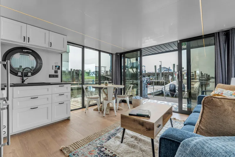 Slide: The Image of Modern Waterlodge Apart EL 2025 interior with kitchen, seating, and marina view. - 13