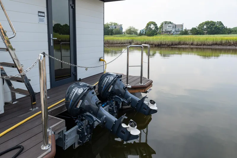 Slide: The Image of Modern Waterlodge Apart EL 2025 houseboat with dual outboard motors on a serene lake. - 32