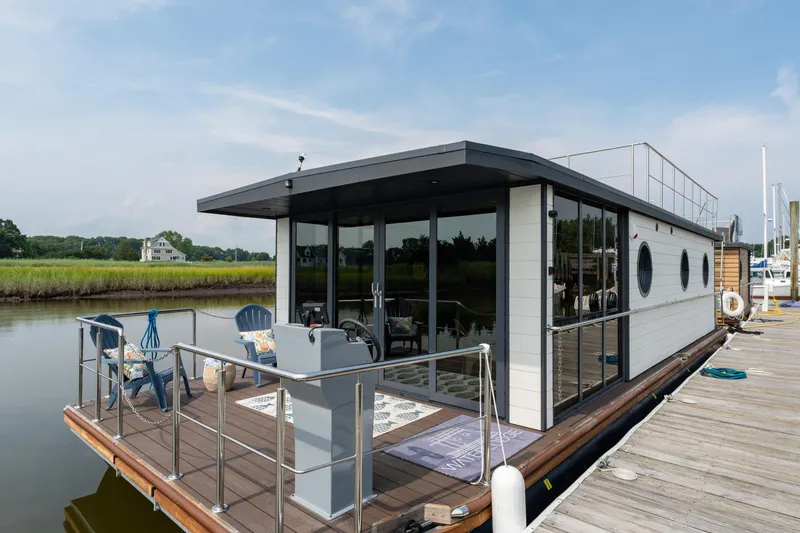 Slide: The Image of Modern 2025 Waterlodge Apart EL houseboat docked, featuring spacious deck and glass windows. - 33