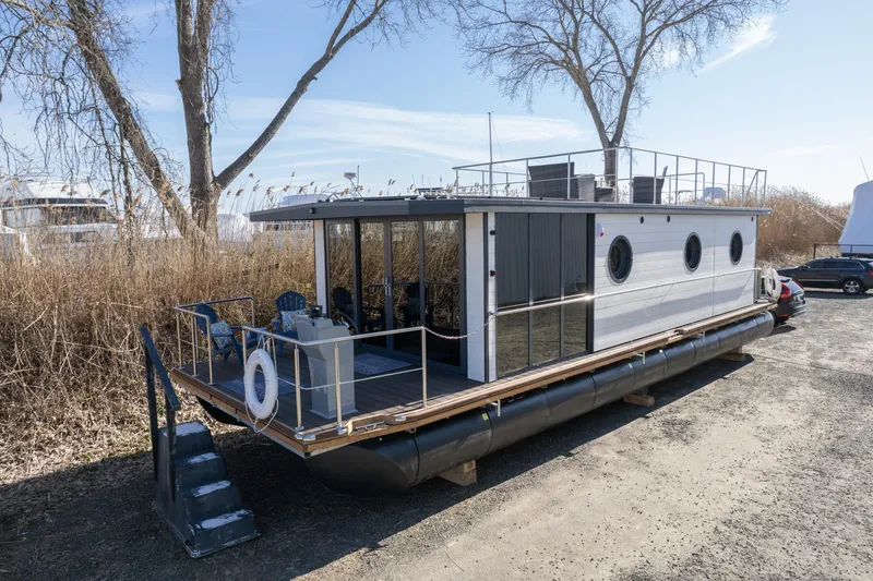 Slide: The Image of Modern 2025 Waterlodge Apart EL houseboat with sleek design, docked on a sunny day. - 4