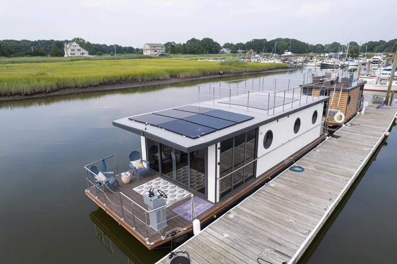 Slide: The Image of Modern Waterlodge Apart EL 2025 houseboat with solar panels docked in a serene marina. - 9