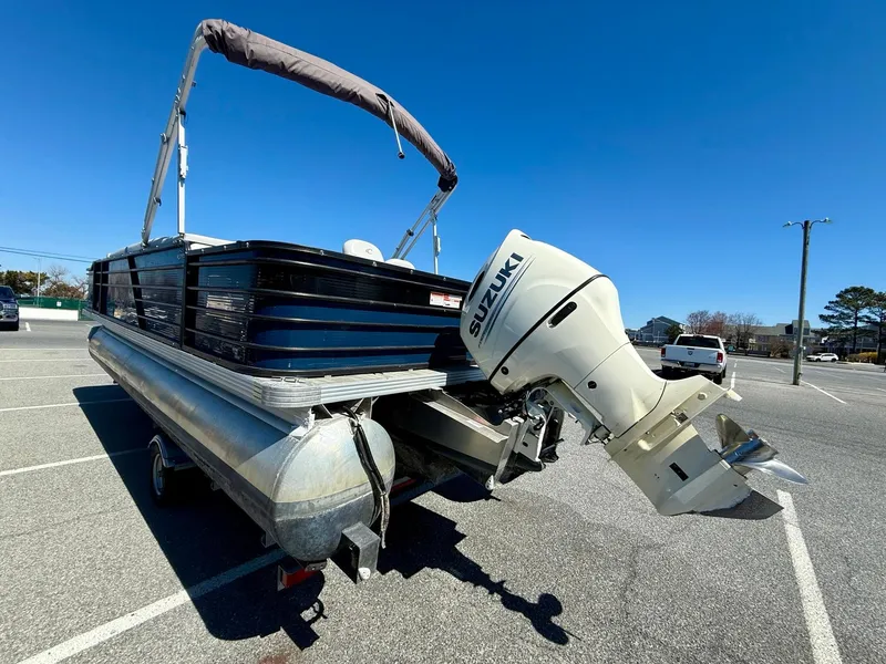 Slide: The Image of 2020 Crest Classic LX Fish 220 SF pontoon boat with Suzuki outboard motor in parking lot. - 17