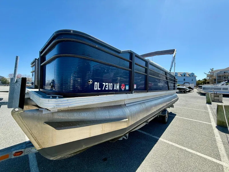 Slide: The Image of 2020 Crest Classic LX Fish 220 SF pontoon boat parked in a sunny lot. - 2