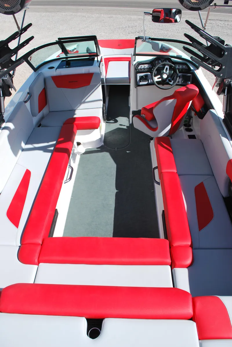 Slide: The Image of 2022 MasterCraft NXT24 boat interior with red and white seating, modern dashboard. - 14