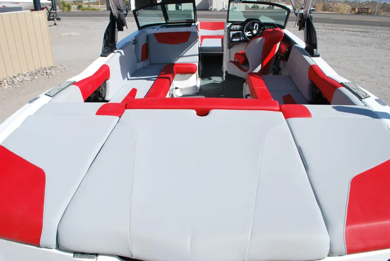 Slide: The Image of 2022 MasterCraft NXT24 boat interior with red and gray seating, open layout. - 15
