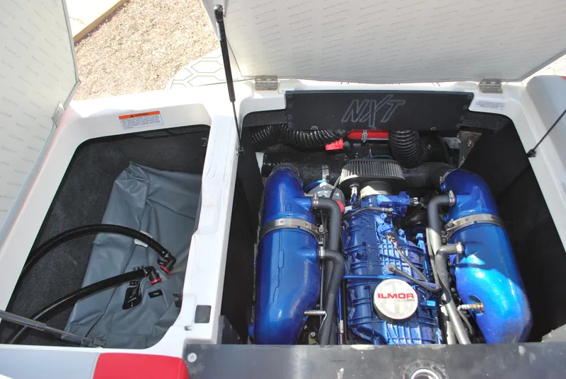 Slide: The Image of 2022 MasterCraft NXT24 engine compartment with Ilmor engine, showcasing blue components and storage area. - 16