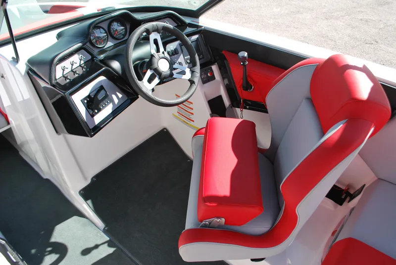 Slide: The Image of 2022 MasterCraft NXT24 boat interior with red and gray seating, modern dashboard, and steering wheel. - 6