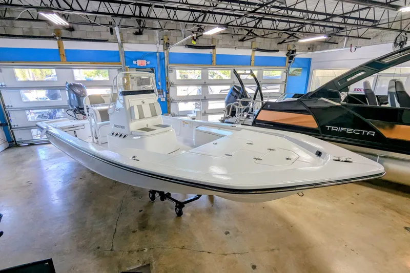 Slide: The Image of 2025 Frontier 2104 boat in showroom, sleek design, white exterior, modern features. - 2