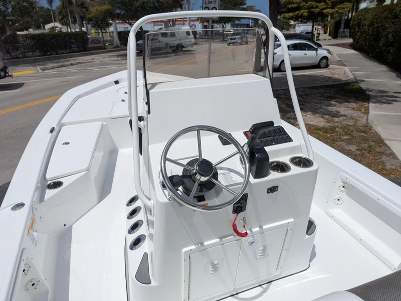 Slide: The Image of 2025 Frontier 2104 boat console with steering wheel and controls, docked outdoors. - 5