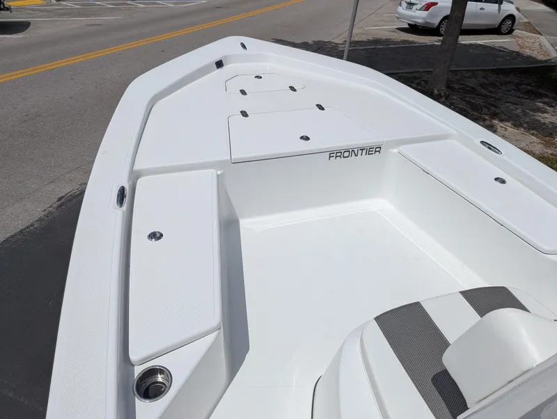 Slide: The Image of 2025 Frontier 2104 boat deck, white with storage compartments, parked on a street. - 9
