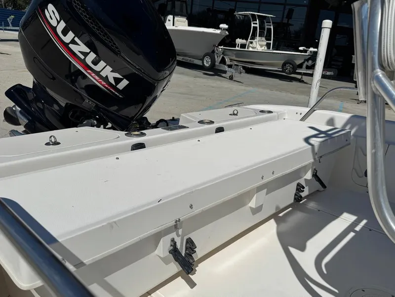 Slide: The Image of 2002 Boston Whaler 220 Dauntless boat with Suzuki outboard motor, docked outdoors. - 14