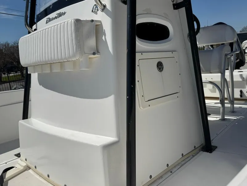 Slide: The Image of 2002 Boston Whaler 220 Dauntless boat console, featuring white seating and storage compartments. - 23